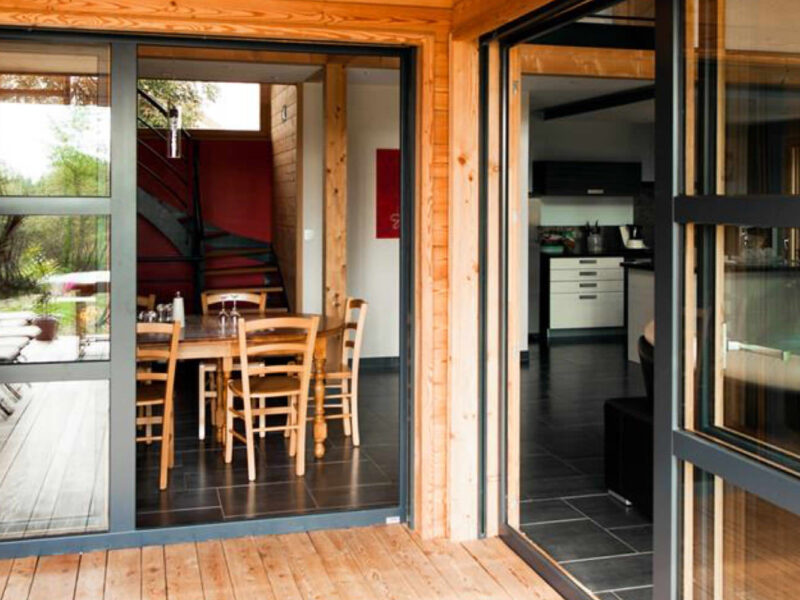 Baies vitr&eacute;es coulissantes dans maison &agrave; ossature bois